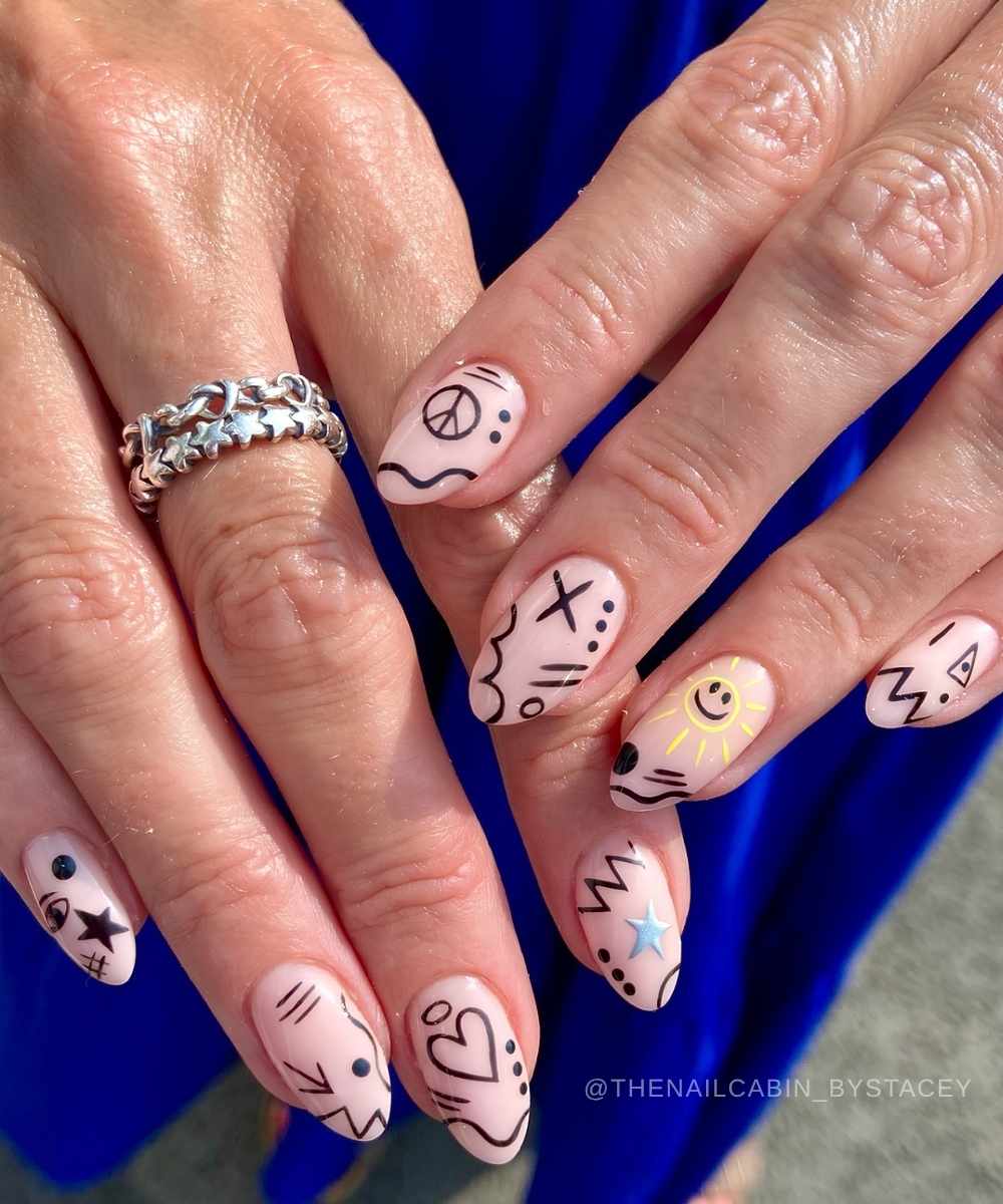 Milky Manikuere mit schwarzen und gelben Doodles