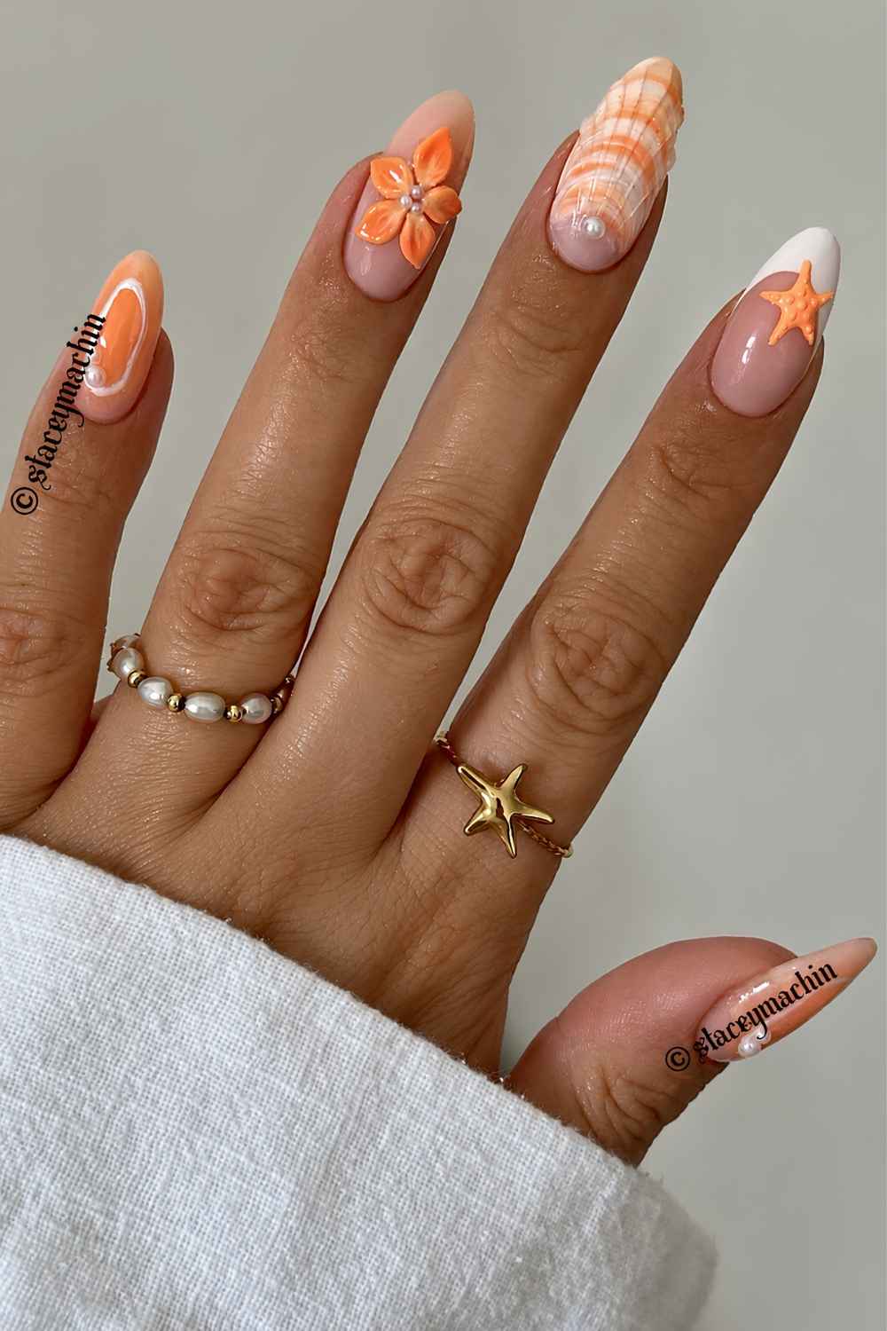 Orange Sommernaegel mit Blumen und Muscheln