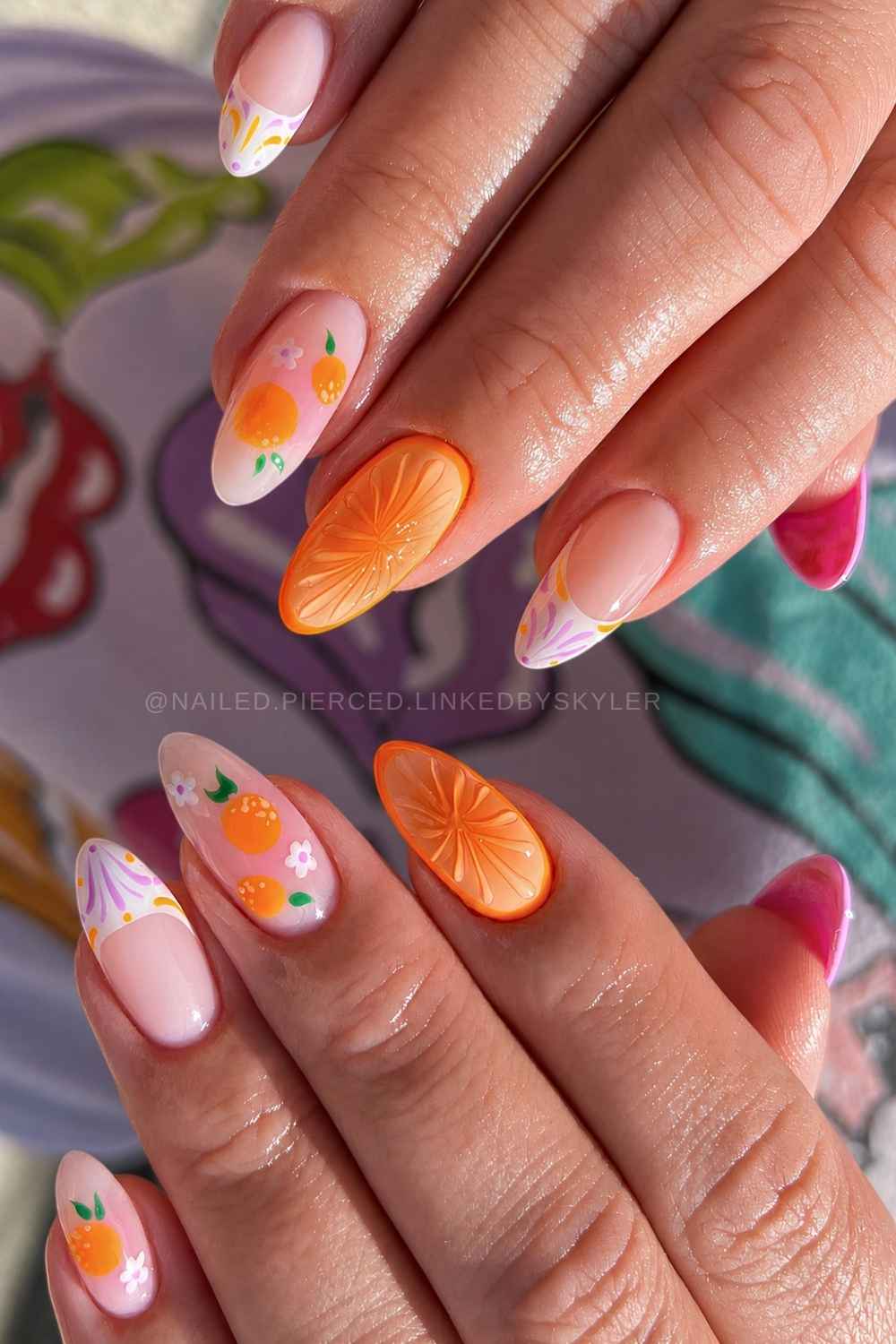 Orange naegel mit zitrus und blumenmotiven