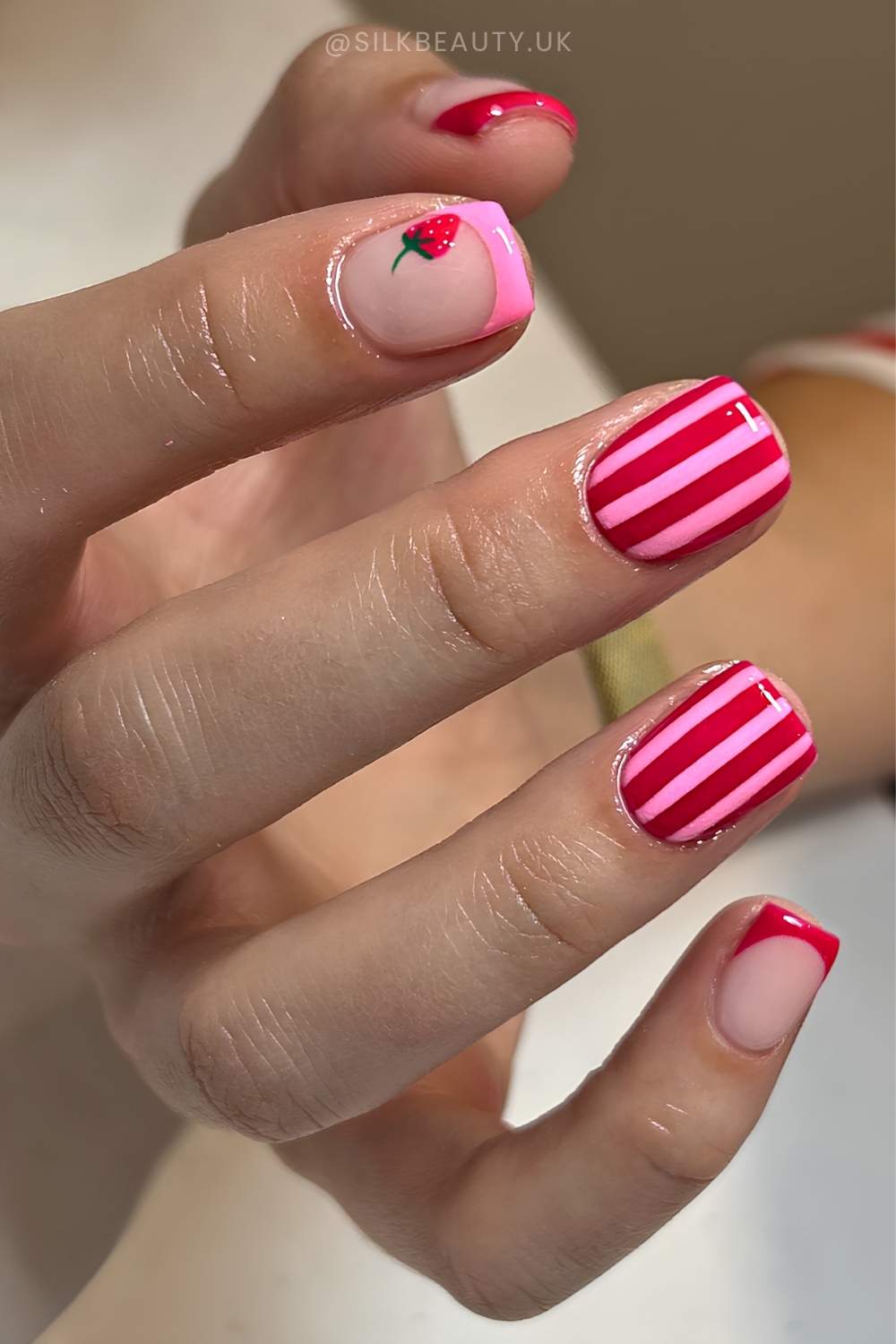 Pink rote Nagel mit Erdbeeren und Streifen