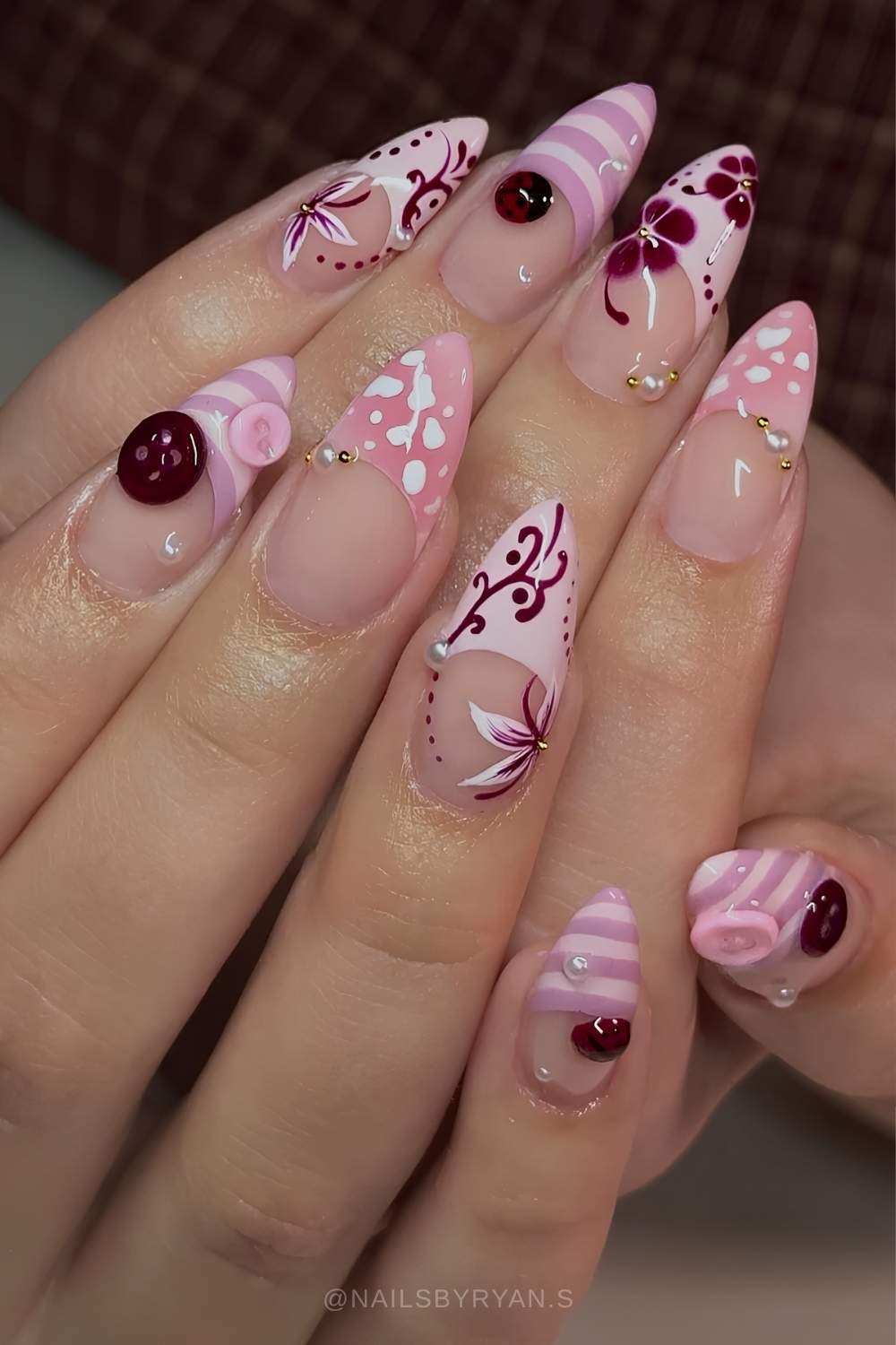 Pinke bordeaux Naegel mit Blumen und Knopfdesign