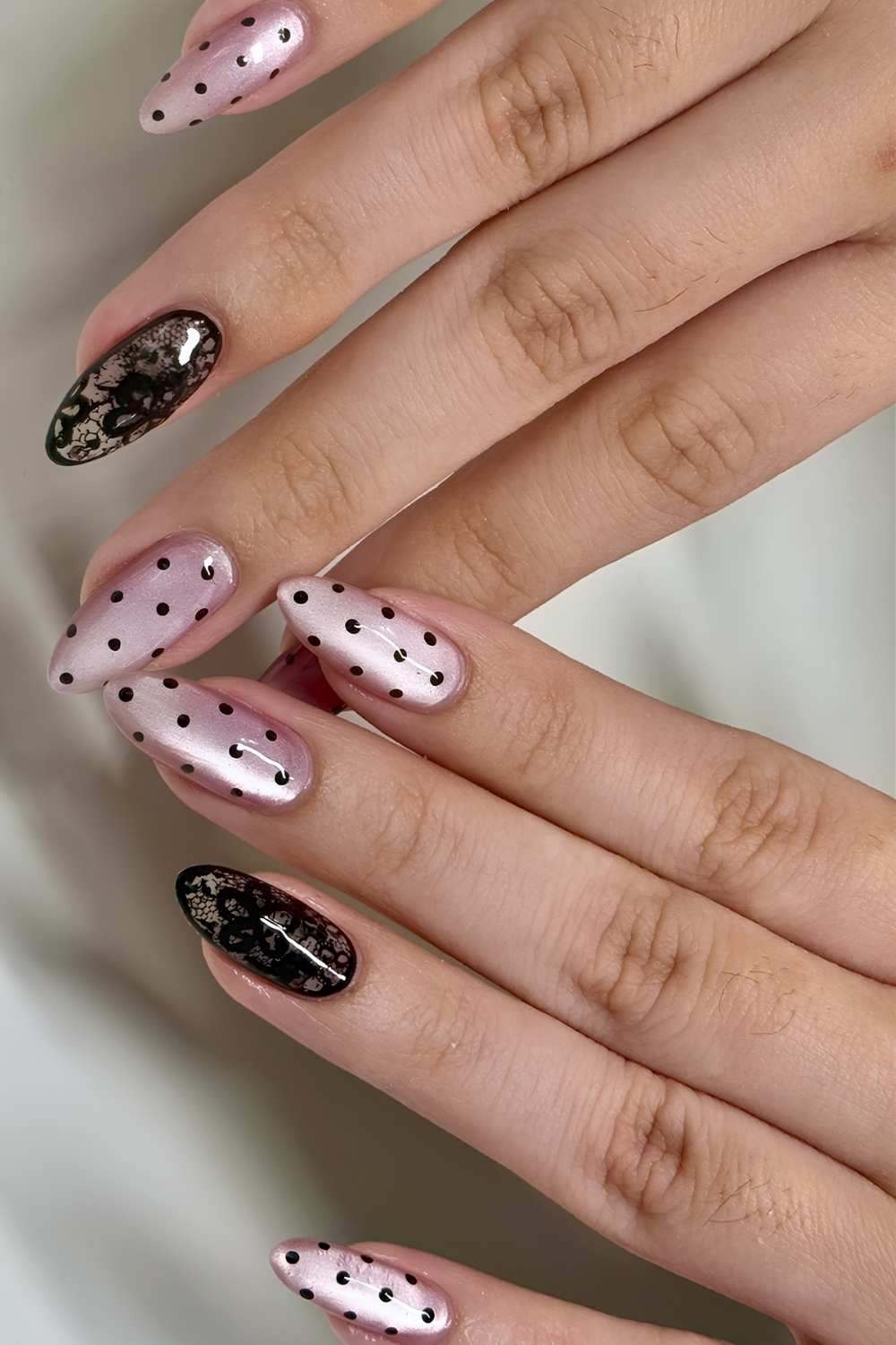 Rosa Cat Eye naegel mit schwarzen punkten und spitze