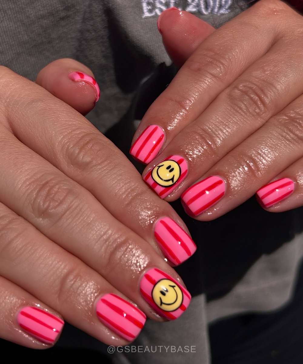 Rosa gestreifte Naegel mit Smiley Motiv