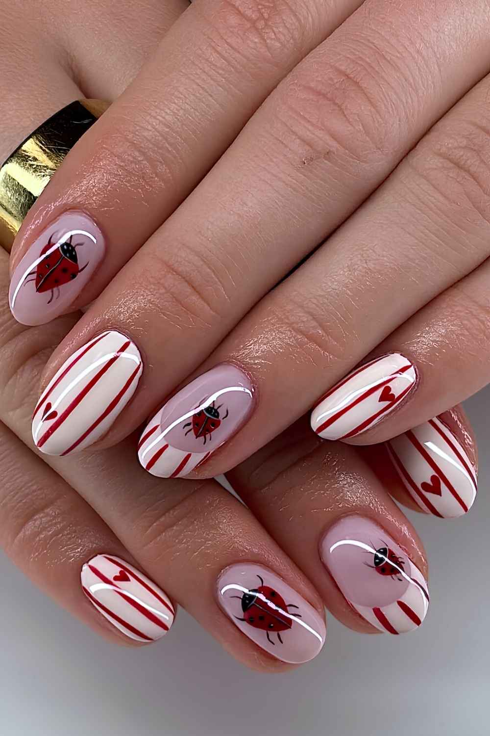 Weisse Mani mit roten Streifen und Marienkaefern