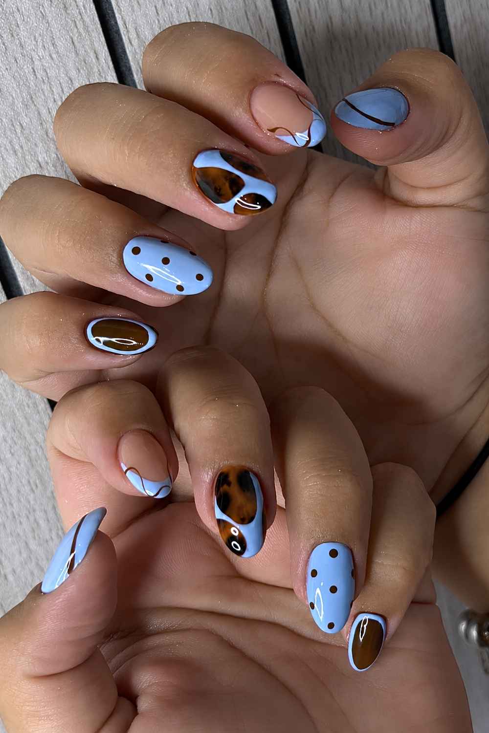 Braun blaue Naegel mit Punkten und Tortie Muster