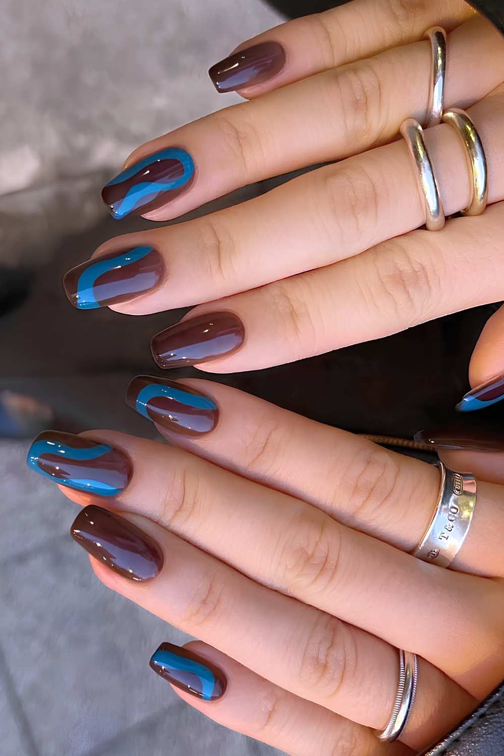 Braune Naegel mit blauen Swirls