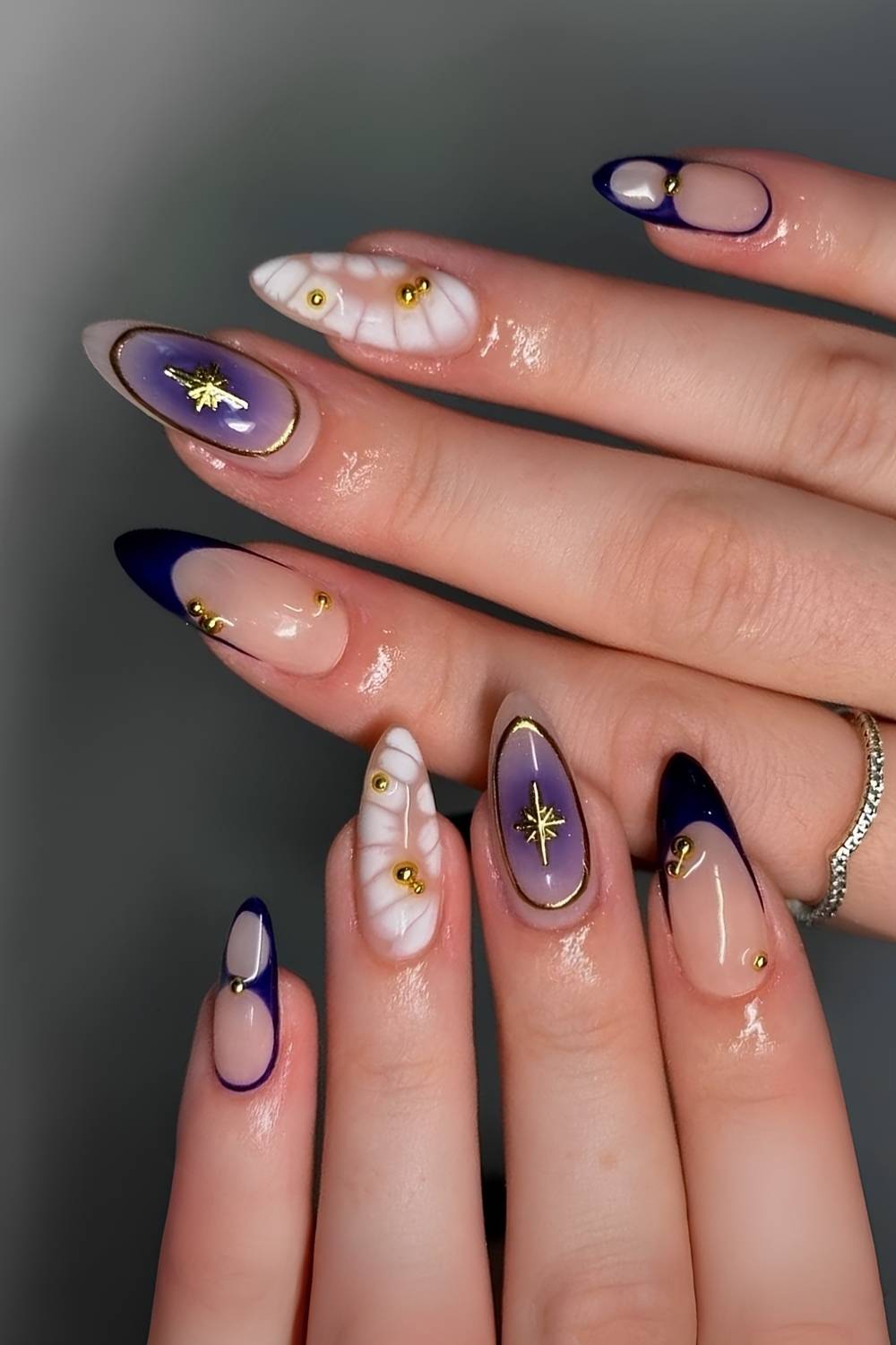 Dunkelblaue und weisse Naegel mit Animal Print und Golddetails
