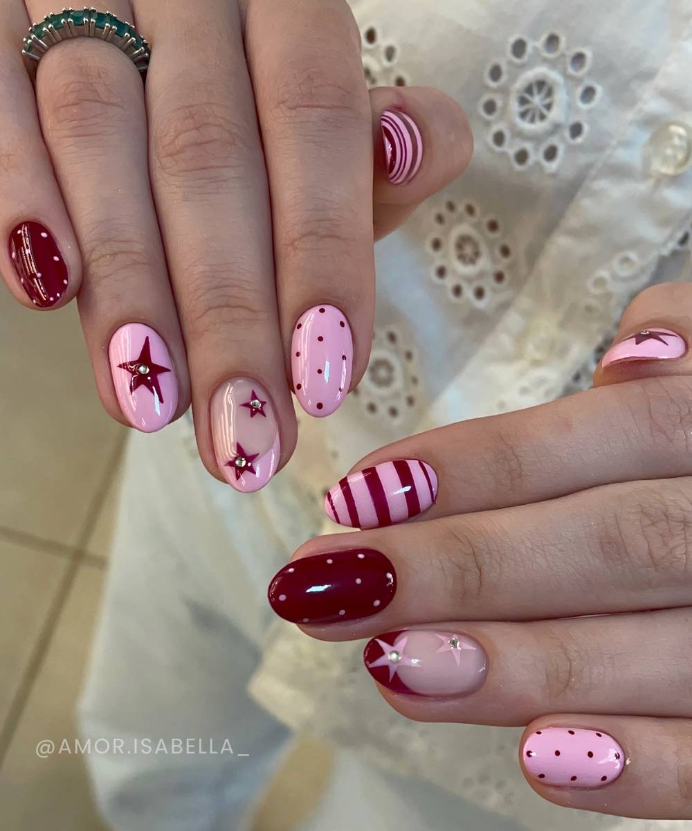 Dunkelrote und rosa Manikuere mit Streifen und Sternen