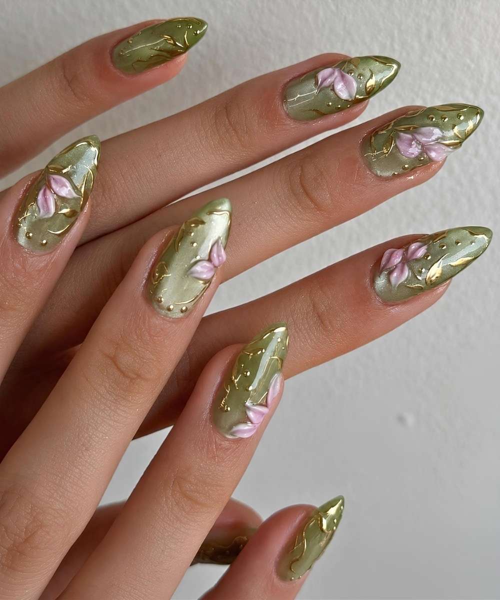 Gruene Cat Eye Manikuere mit pinken Blumen und Goldakzenten