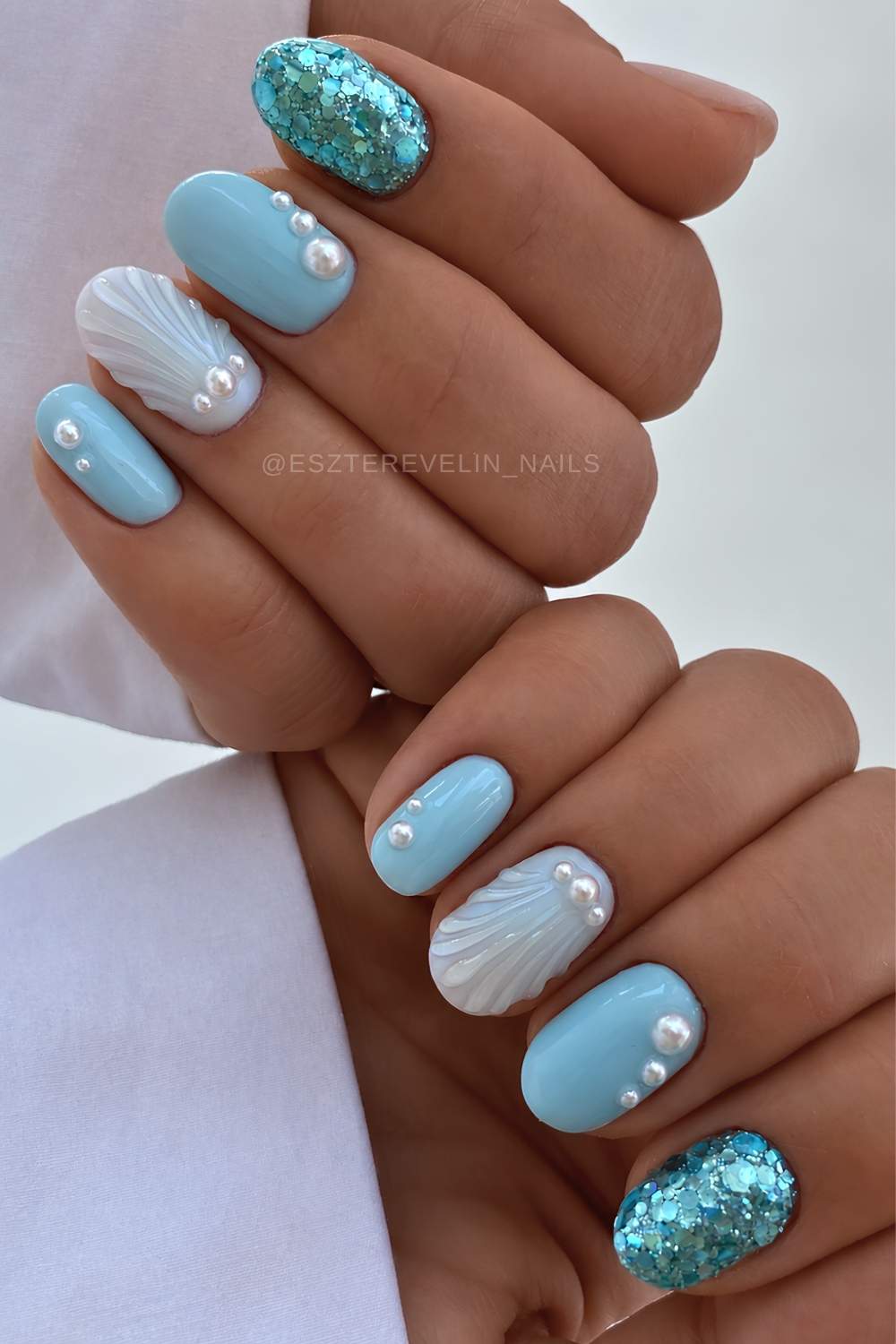 Kurze blaue Naegel mit Muscheln und Perlen