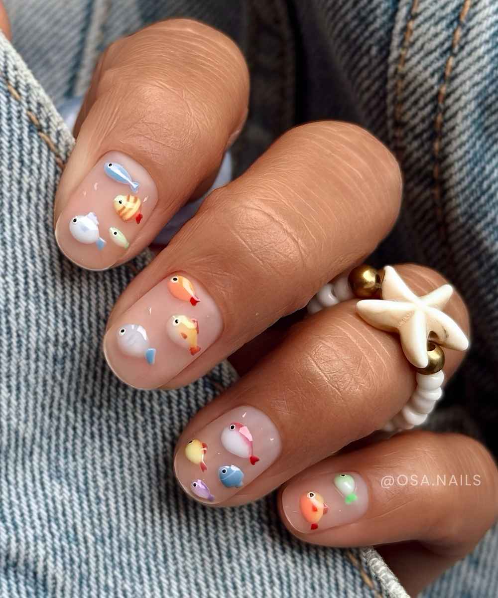 Kurze transparente Naegel mit buntem Fisch Motiv