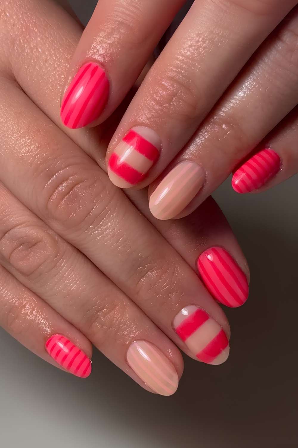 Pink rote Naegel mit Streifenmuster