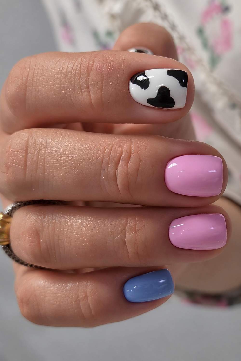 Rosa und blaue Naegel mit Kuhmuster
