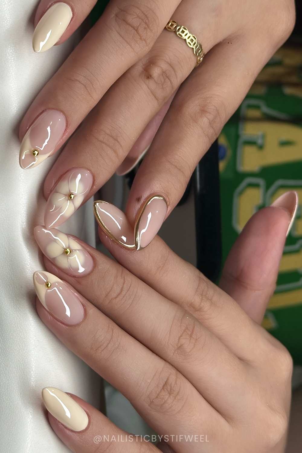 Vanille Manikuere mit Blumen und goldenen Konturen