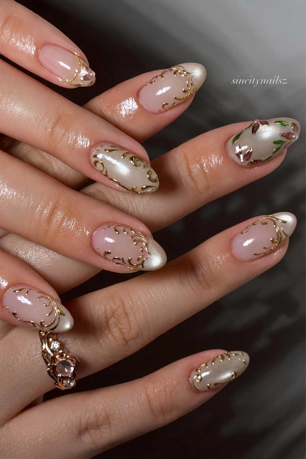 Zartgruene Cat Eye Naegel mit Blumen und goldenen Schnoerkeln
