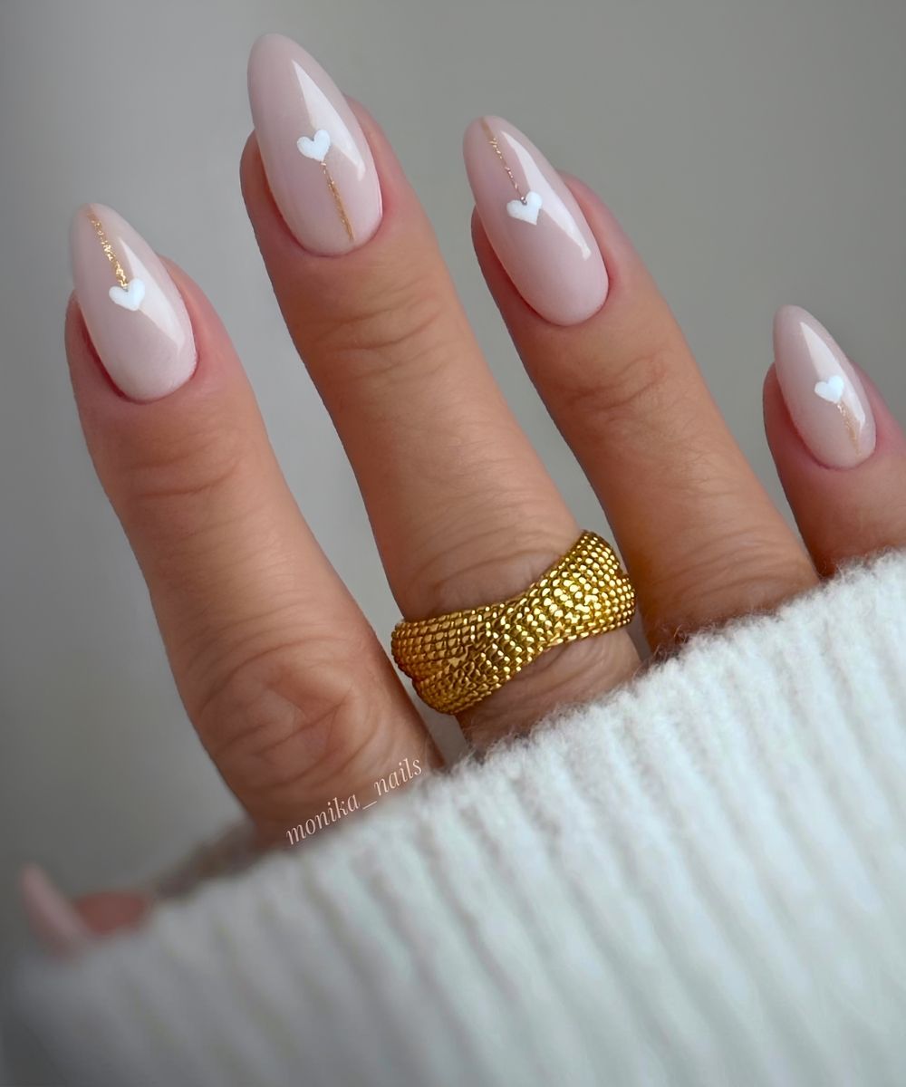 Beige Naegel mit weissen Herzen und Glitzer