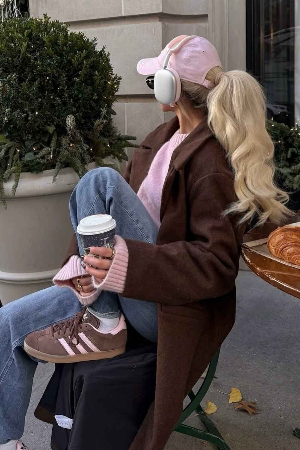 Brauner Mantel mit pinkem Pullover und pinker Cap