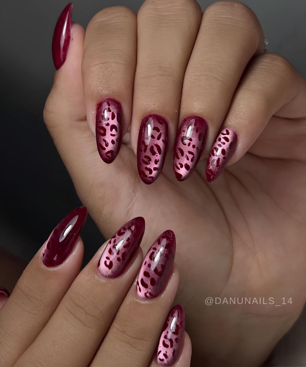 Dunkelrote cat eye naegel mit tiermuster
