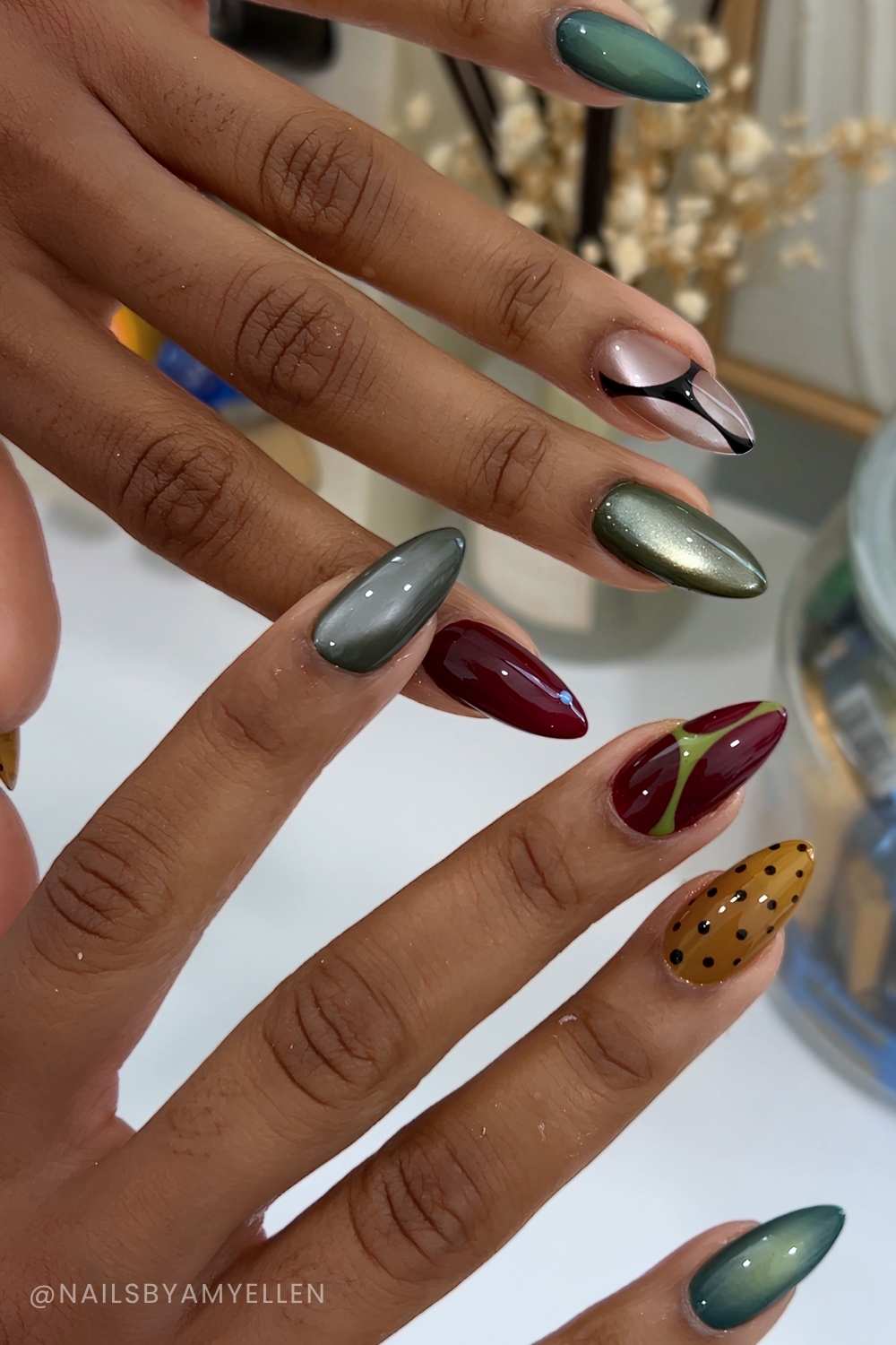 Gruene und burgundy cat eye mani mit linien und punkten