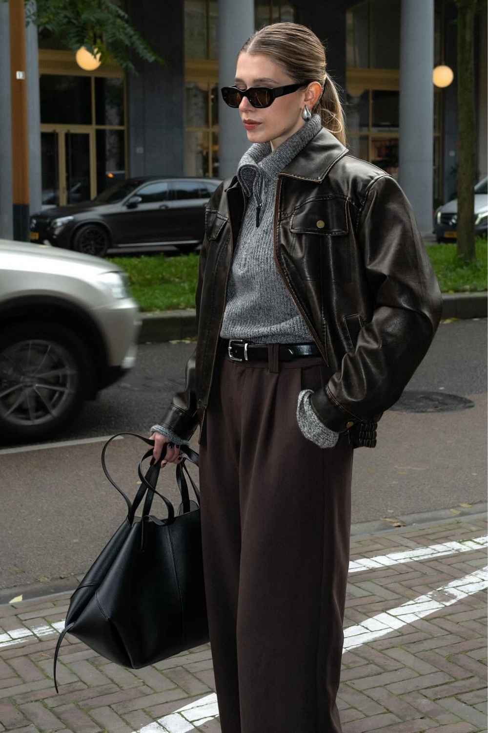 Lederjacke mit grauem Quarter Zip und weiter Hose
