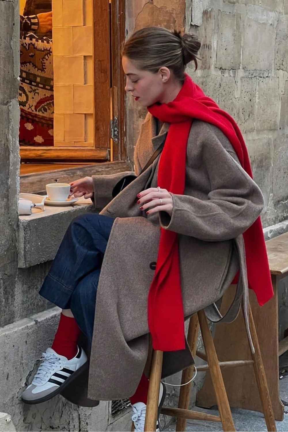 Taupe Wollmantel mit rotem Schal und roten Socken