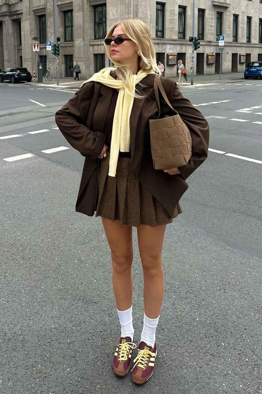 Brauner Blazer mit Faltenminirock und Sneakern