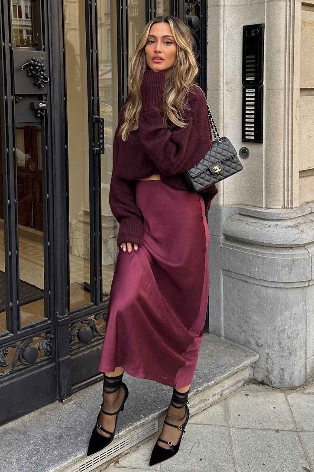 Burgunderroter Pullover mit Satinrock und schwarzen Pumps