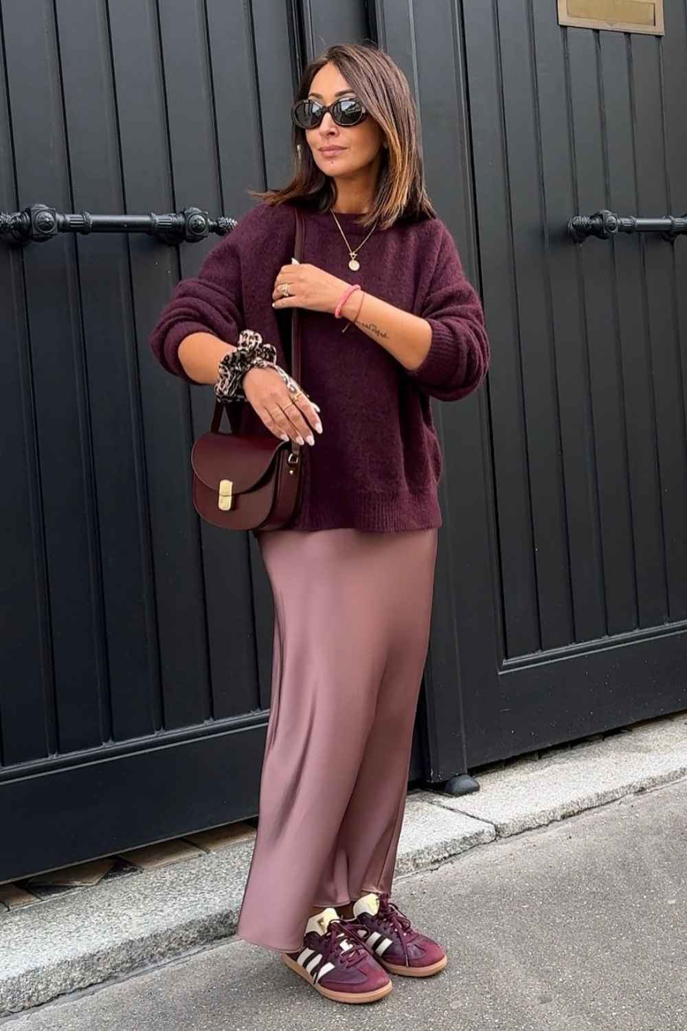 Burgunderroter Pullover mit rosa Satinrock und Sneakern