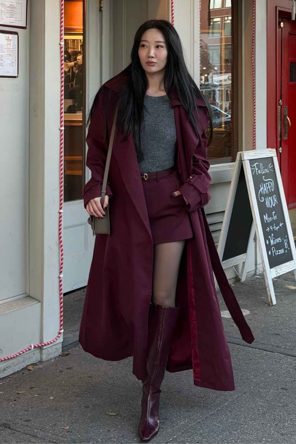 Burgunderroter Trenchcoat mit Shorts und hohen Stiefeln