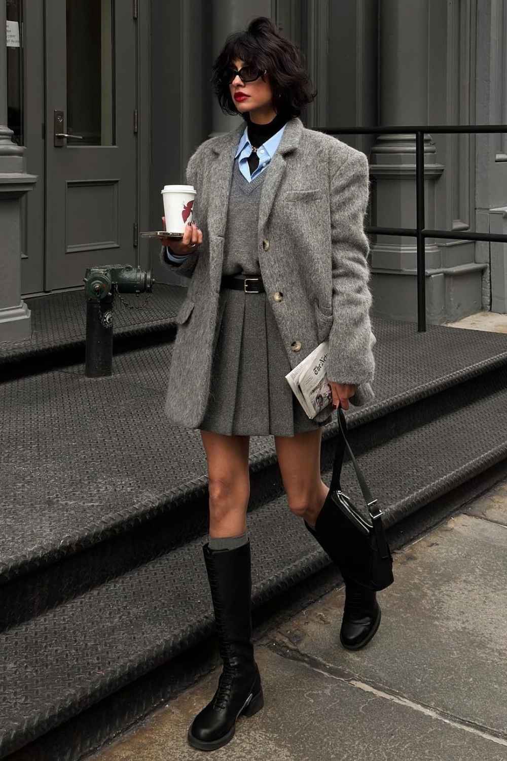 Flauschiger grauer Blazer mit Faltenmini und kniehohen Stiefeln