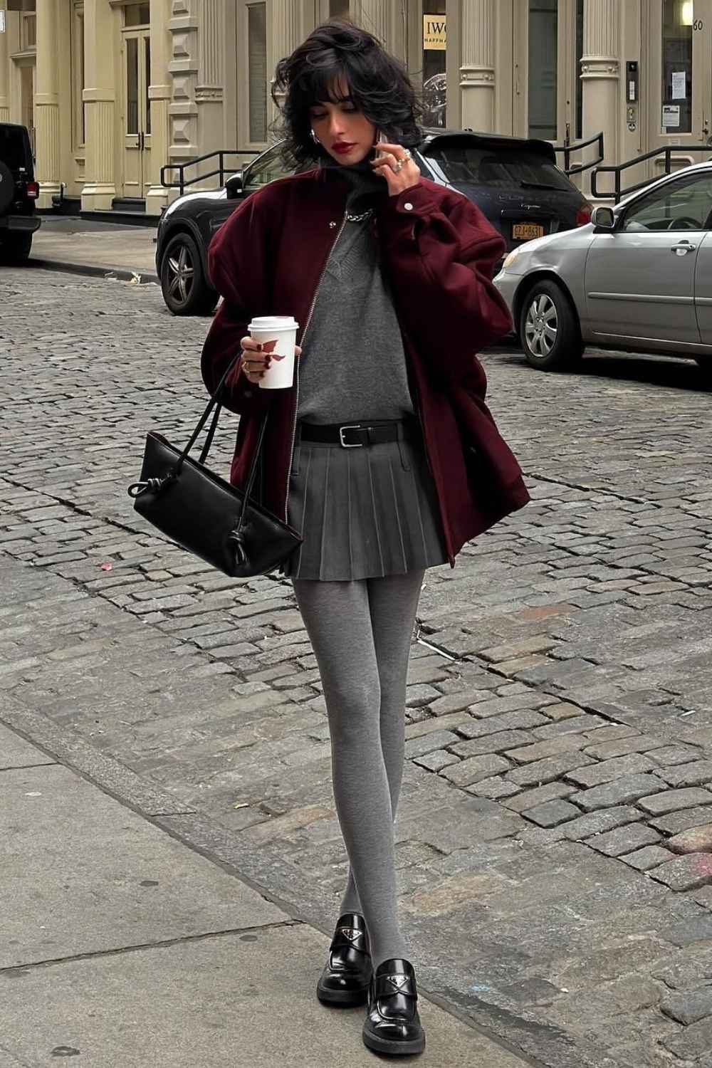 Graue Strumpfhose mit Faltenmini und bordeauxroter Bomberjacke