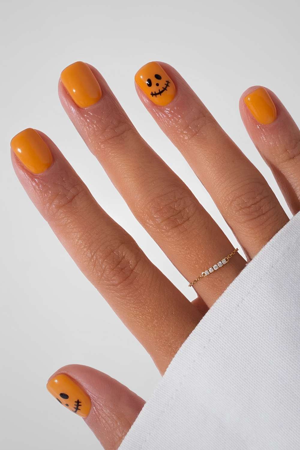 Kurze Orange Naegel mit Jack O Lantern Design