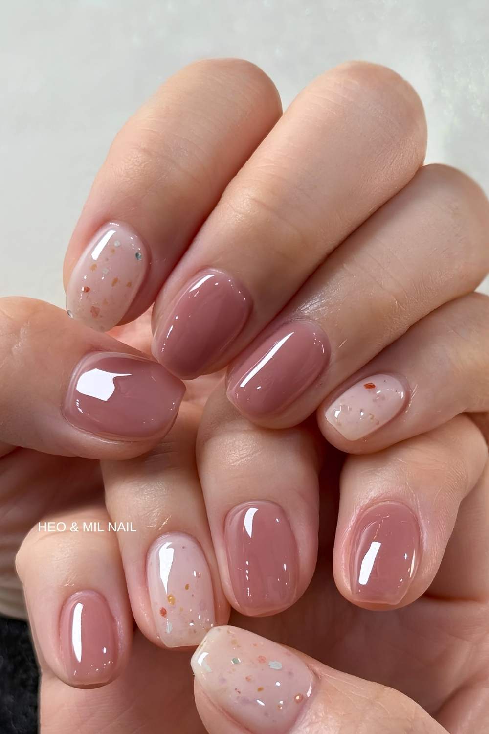 Kurze mauvefarbene Naegel mit Holo Flakes