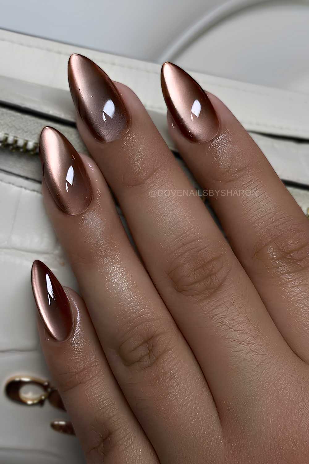 Lange mandelfoermige braune Cat Eye Naegel