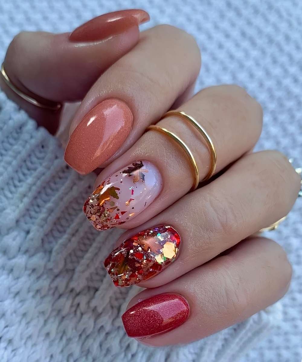 Rote und orange Mani mit Glitzer und Blaettern