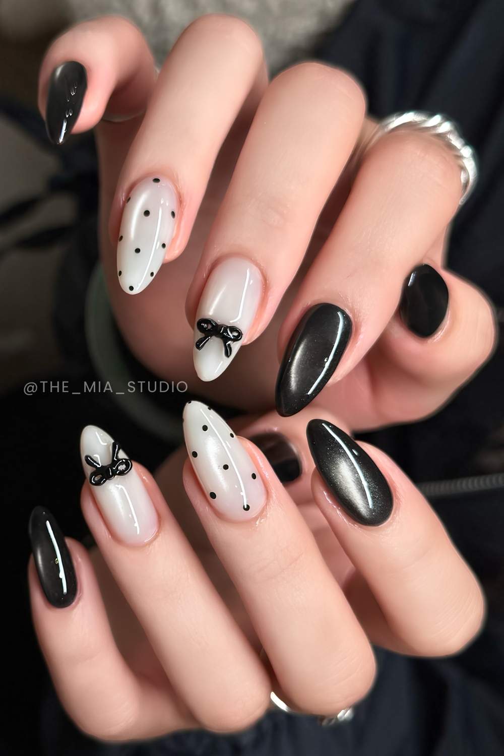 Schwarz weisse Cat Eye Naegel mit Schleifen und Punkten
