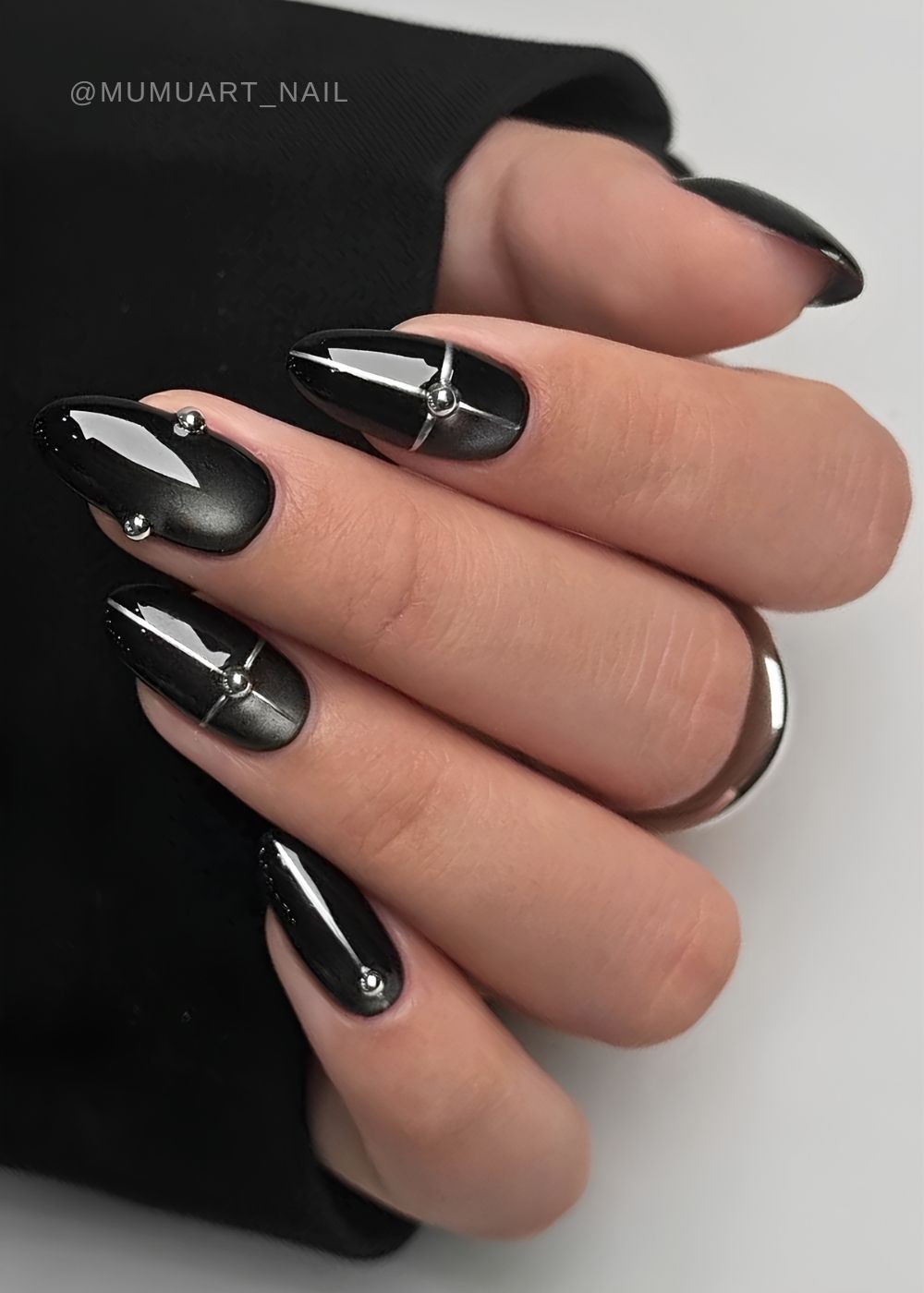 Schwarze Cat Eye Naegel mit Silberlinien und Nieten