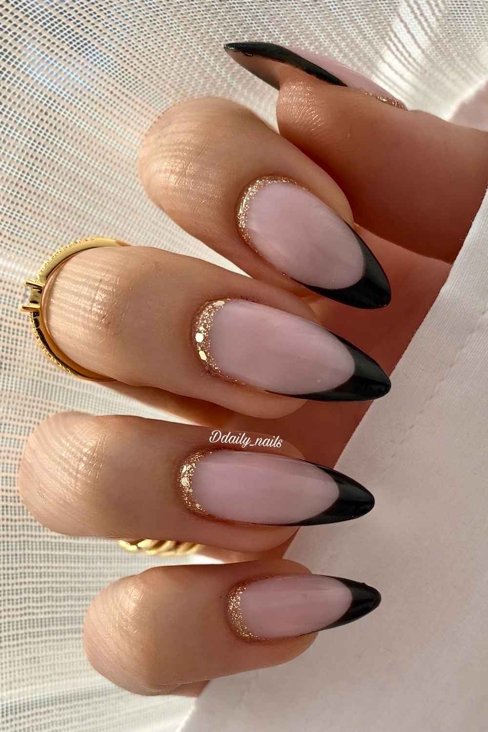 Schwarze French Naegel mit Goldglitzer am Nagelansatz