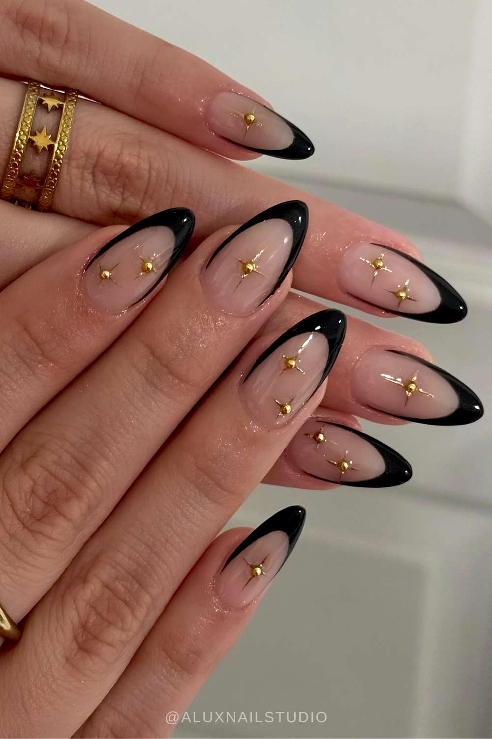 Schwarze French Naegel mit goldenen Sternmotiven