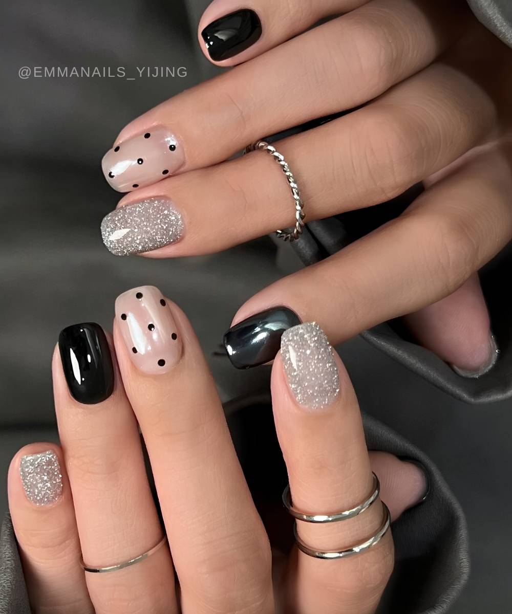 Schwarze und silberne Naegel mit Glitzer und Punkten